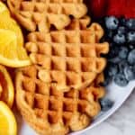 cold brew coffee waffles on white plate with fresh fruit.
