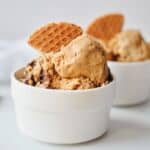 nutella coffee ice cream scoops in white bowl with waffle biscuit.