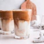 greek frappe in tall glass, with milk on bottom and coffee mixture on top.