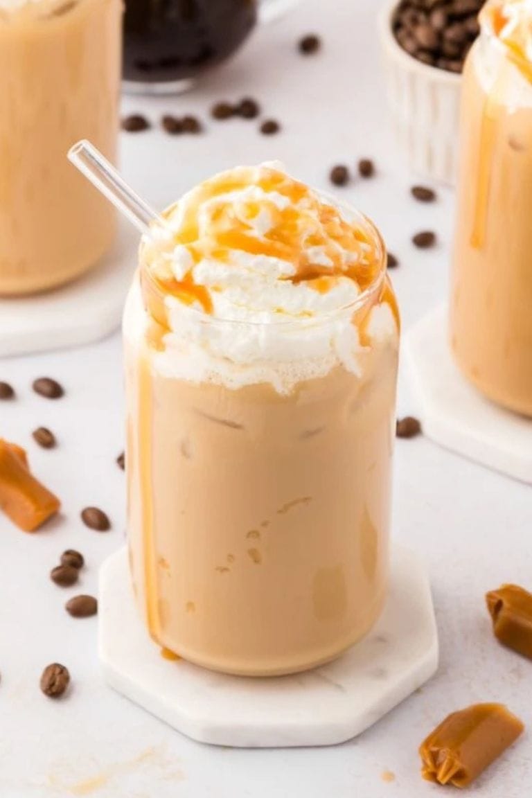 iced caramel latte topped with whipped cream in glass.