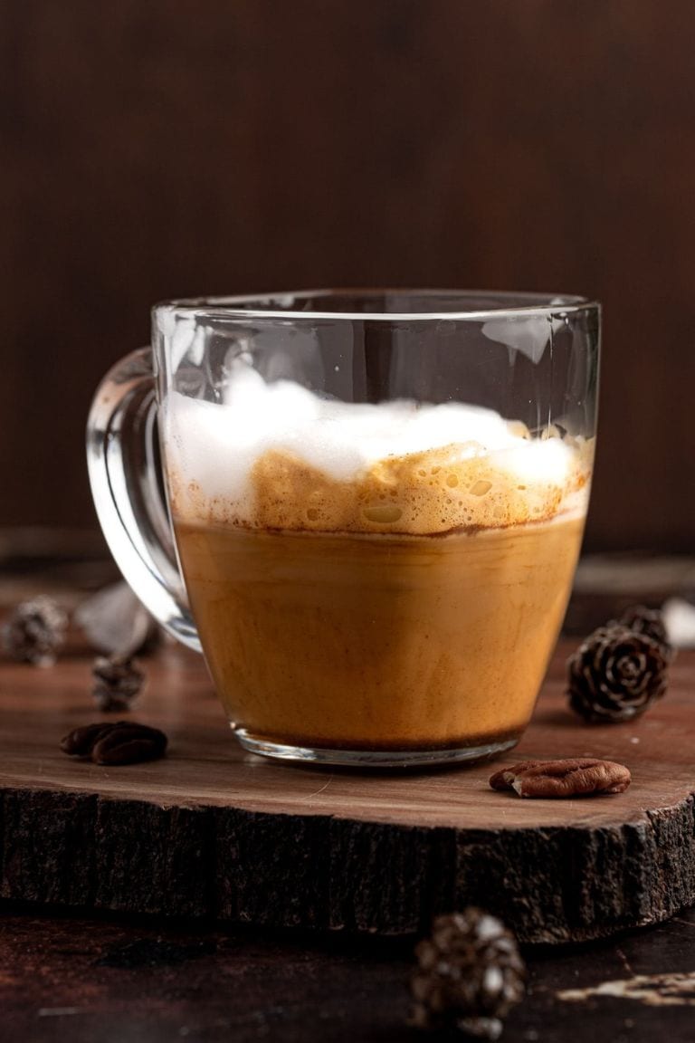 hot maple flavored latte in glass mug.