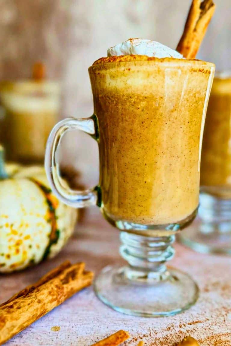 spiced pumpkin milk steamer in tall glass mug.