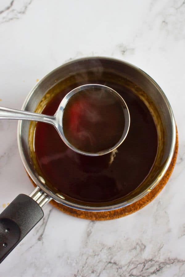 thick coffee cheesecake topping on spoon above pan.