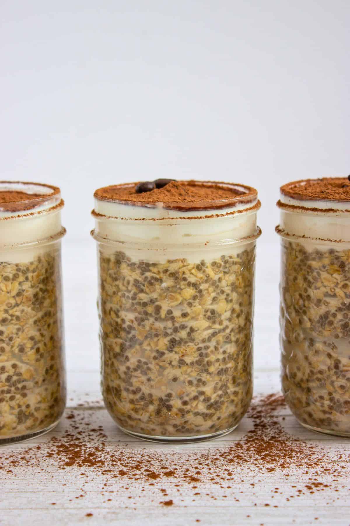 tiramisu overnight oats in a jar dusted with cocoa powder.