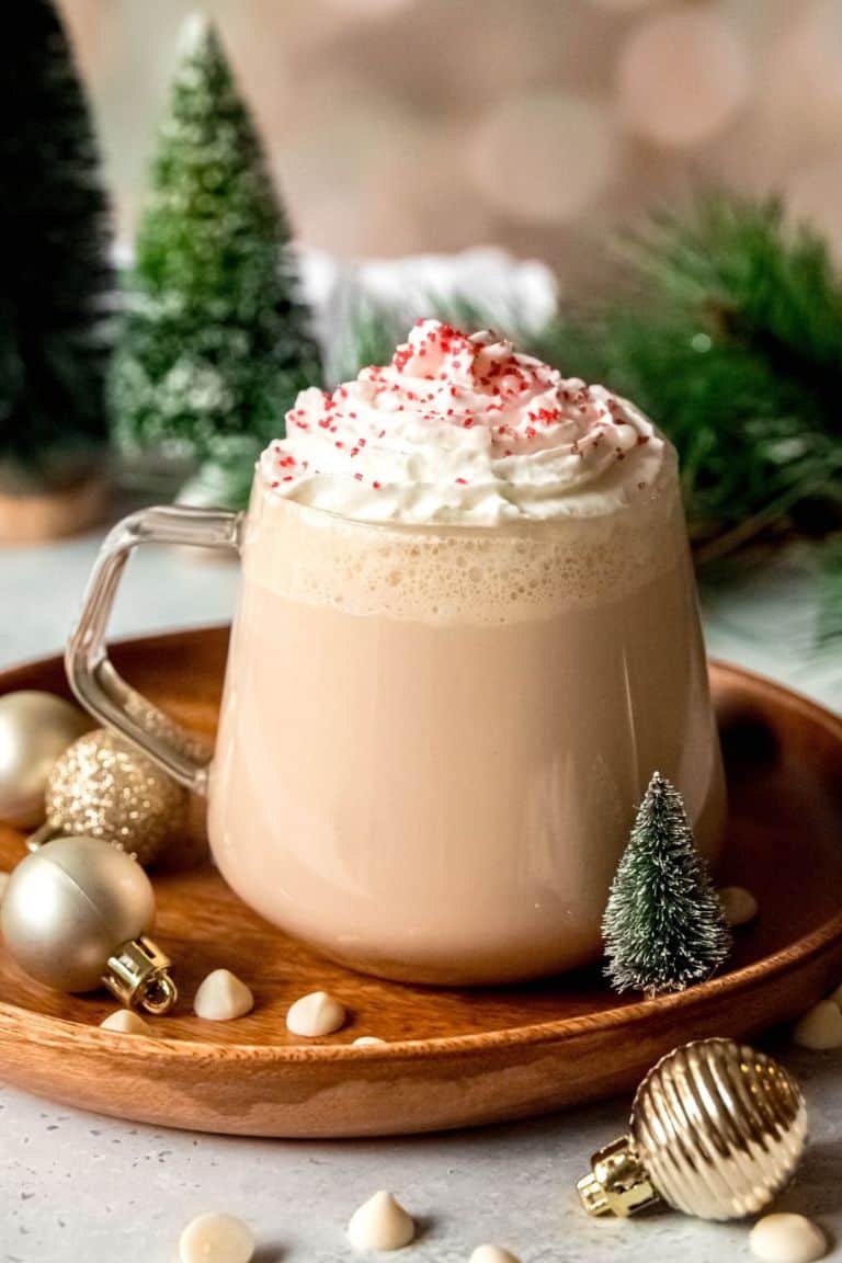 white chocolate mocha in glass mug with christmas decorations.