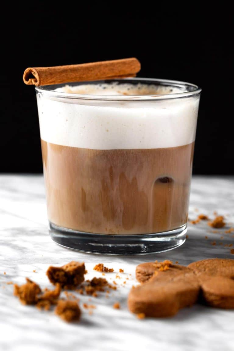 festive gingerbread iced latte in short glass with cinnamon stick.