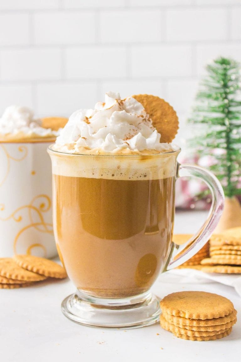 hot gingerbread latte topped with whipped cream in glass mug.