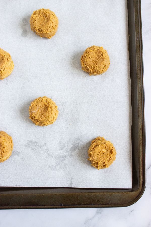 flattened pumpkin cookie balls on tray.