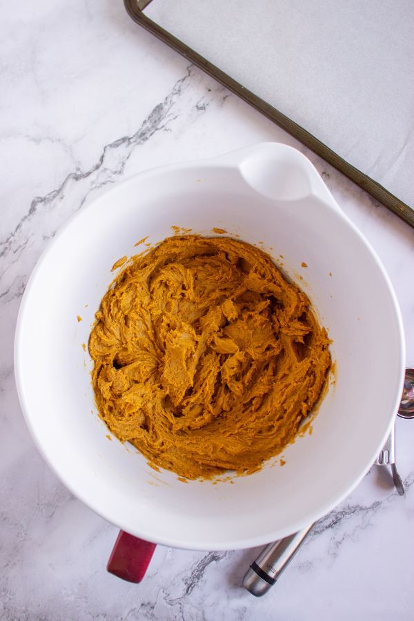 pumpkin cookies mixture next to cookie tray.