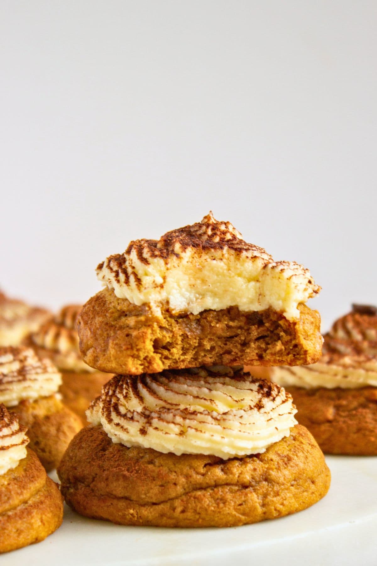 tiramisu pumpkin cookies with mascarpone frosting stacked.