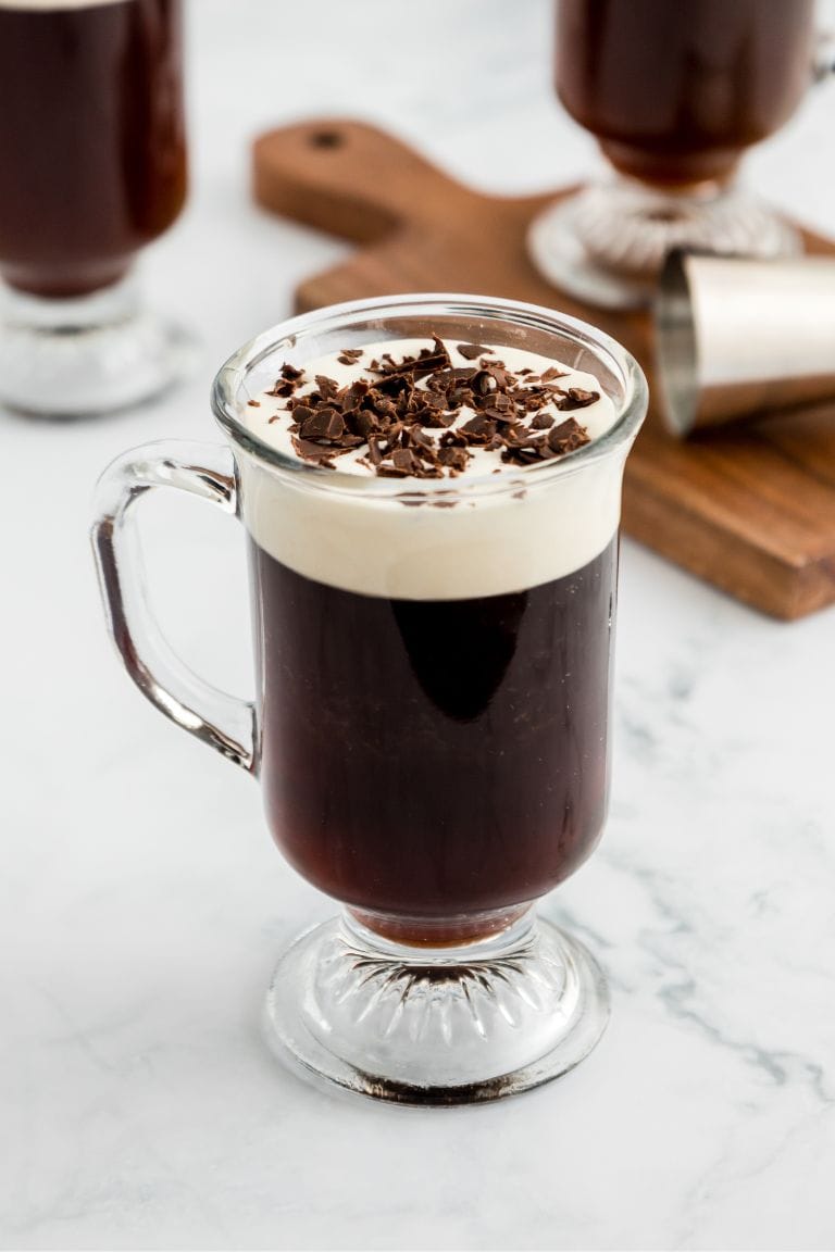 irish coffee in glass mug with whipped cream and chocolate shavings.