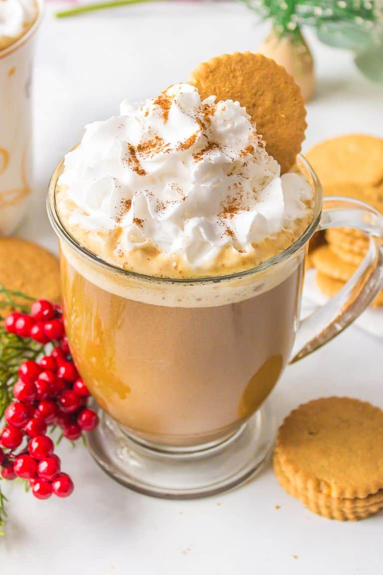 hot gingerbread latte with whipped cream in glass mug.