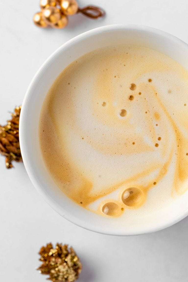 top view of caramel cappuccino in white mug.