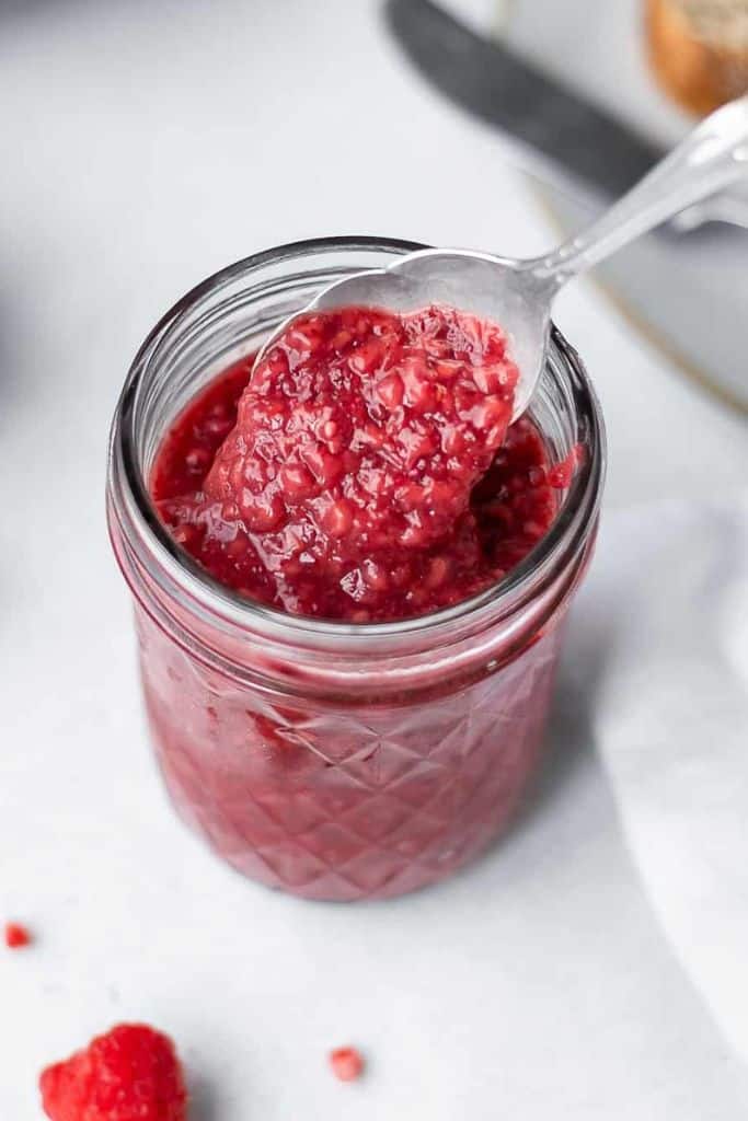 berry chia seed jam in a jar with spoon.