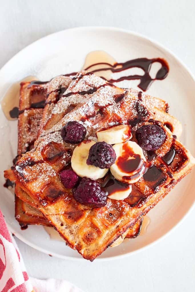 chocolate chip chia waffles with chocolate sauce and berries.