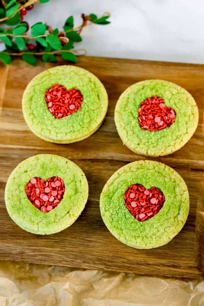 cutout grinch sugar cookies with hearts.