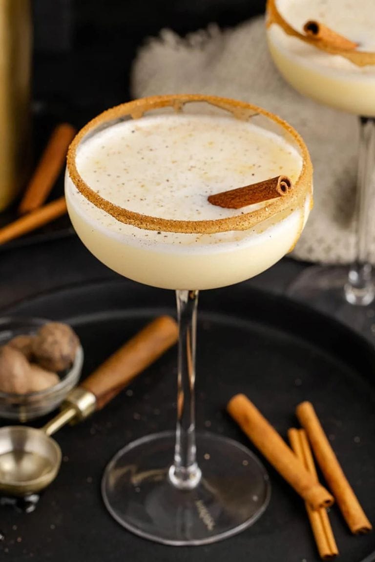 eggnog martini in martini glass rimmed with sugar.