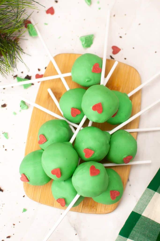 grinch cake pops on platter.