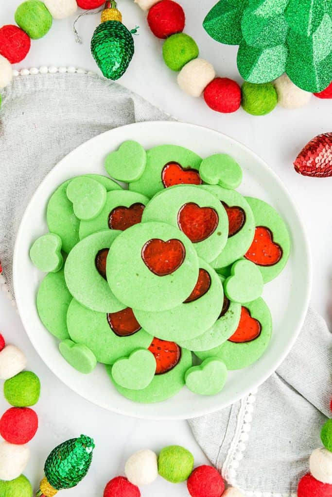 grinch heart cut out cookies on plate.