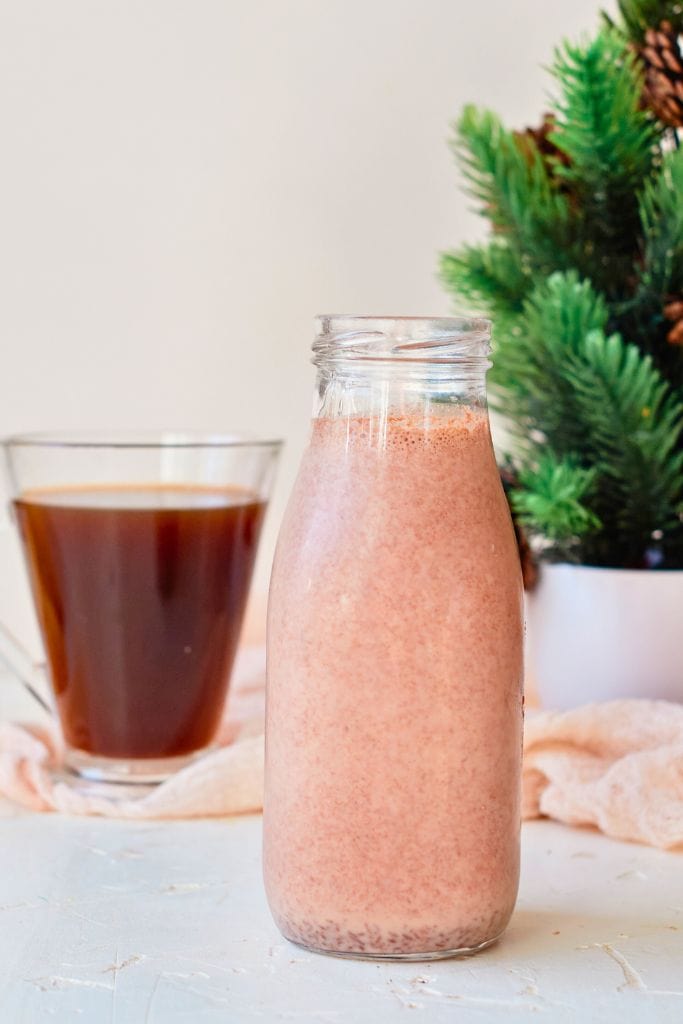 jar of peppermint mocha creamer alongside a black coffee drink.
