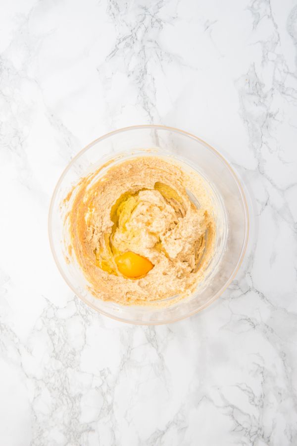egg in cookie mixture in mixing bowl.