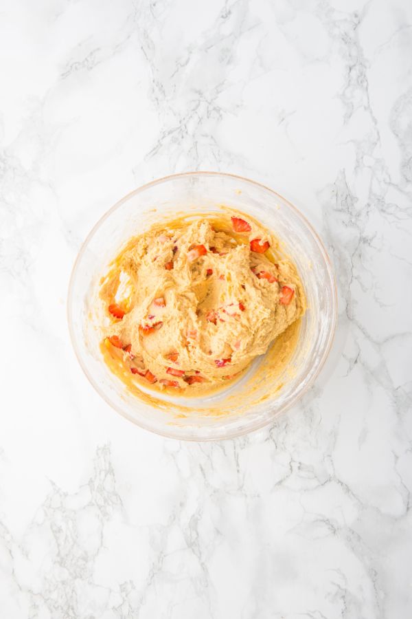 diced strawberries in cookie mixture in bowl.