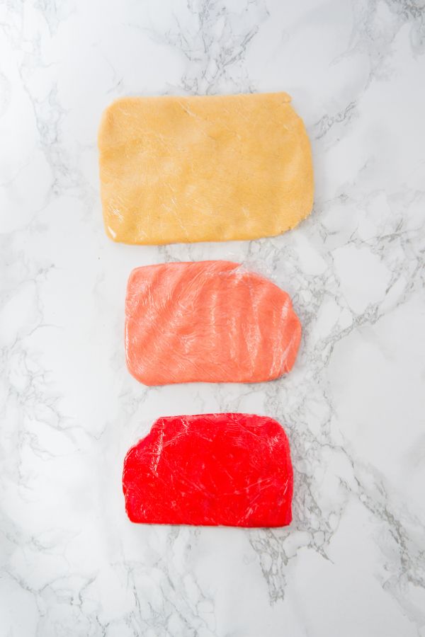 three colored cookie doughs wrapped.