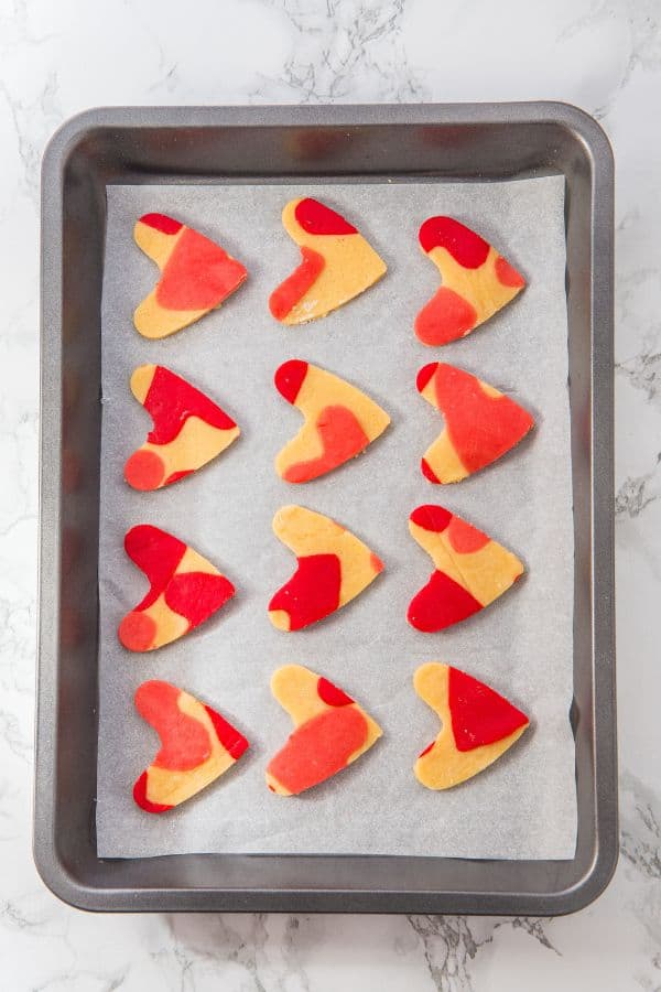 marbled pink love heart cookies on tray.