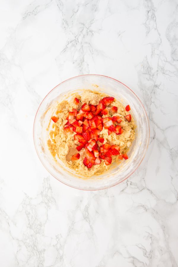 fresh chopped strawberries sitting on top of cookie mixture.