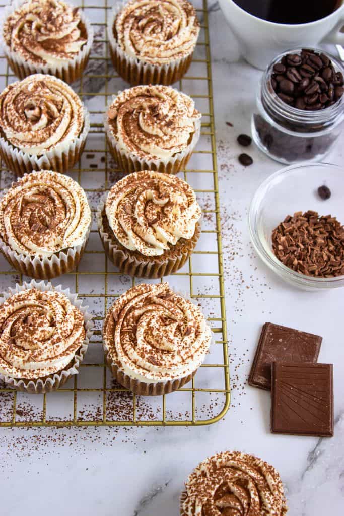 frosted tiramisu cupcakes on wire rack.