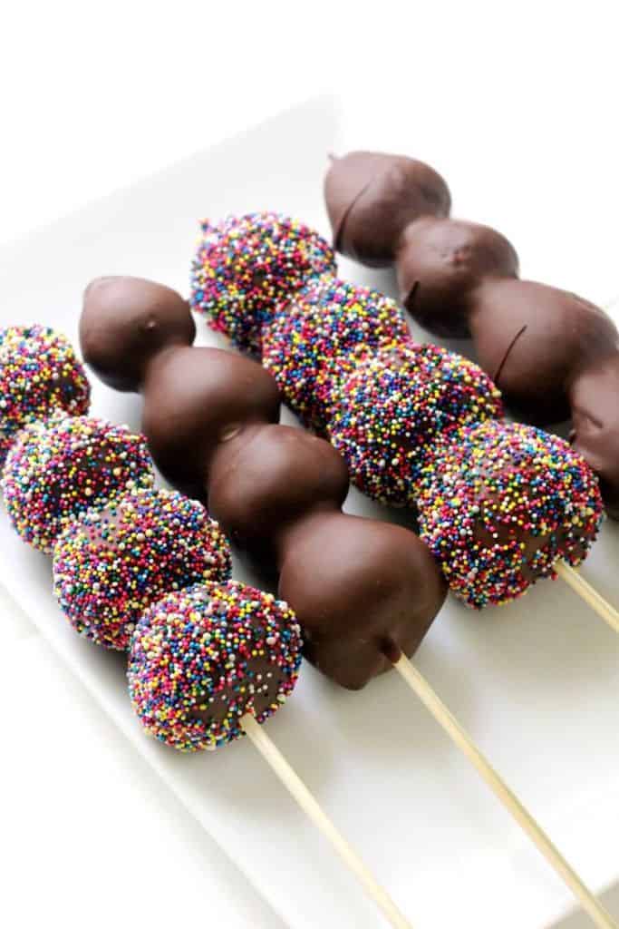 chocolate covered strawberry skewers with sprinkles.