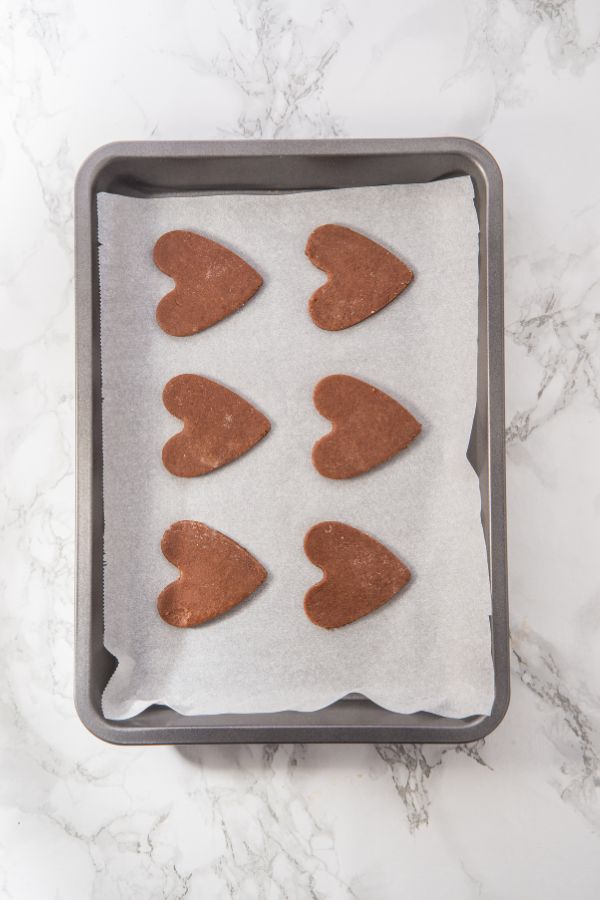 unbaked heart sugar cookies on tray.