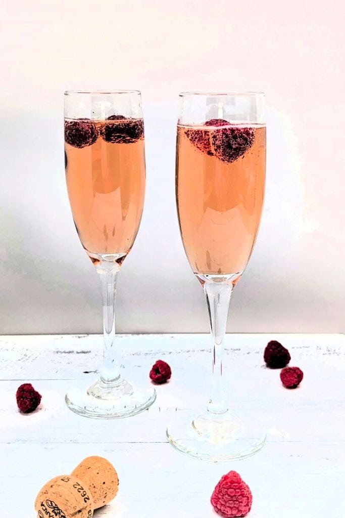 kir imperial champagne cocktail with raspberry garnish.