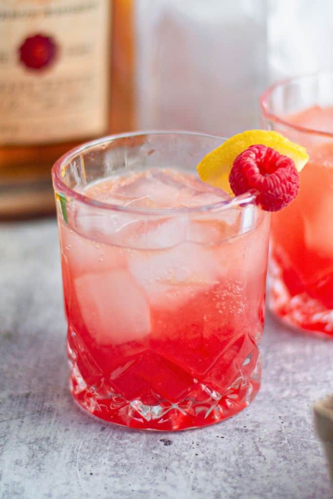 raspberry bourbon smash in short glass with ice.