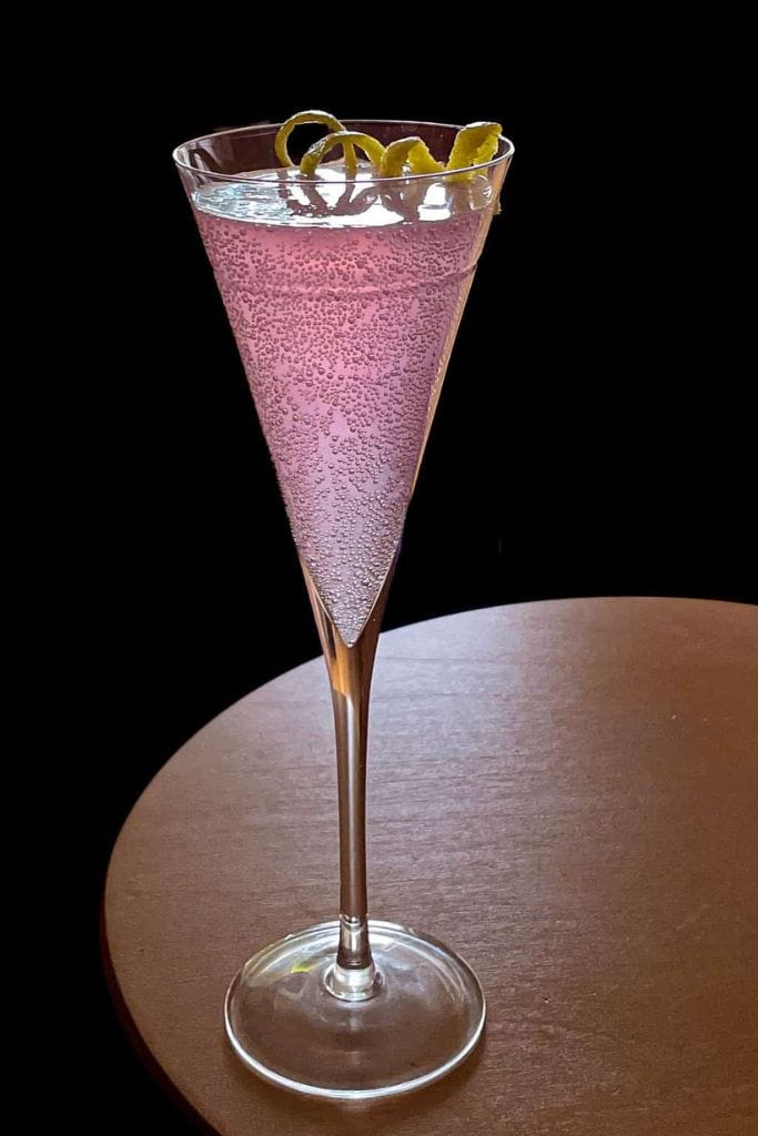 rose syrup french 75 cocktail in champagne glass.