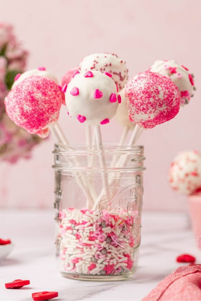 decorated pink and white cake pops in a jar.