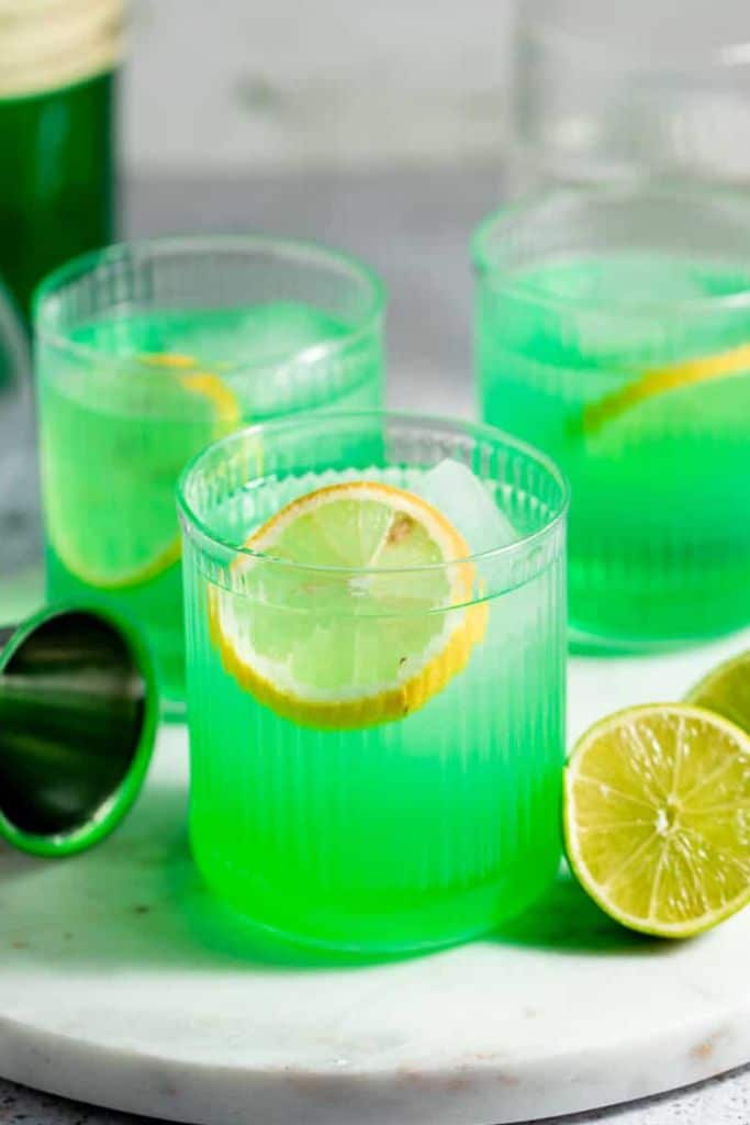 green midori sour drink in short glass.