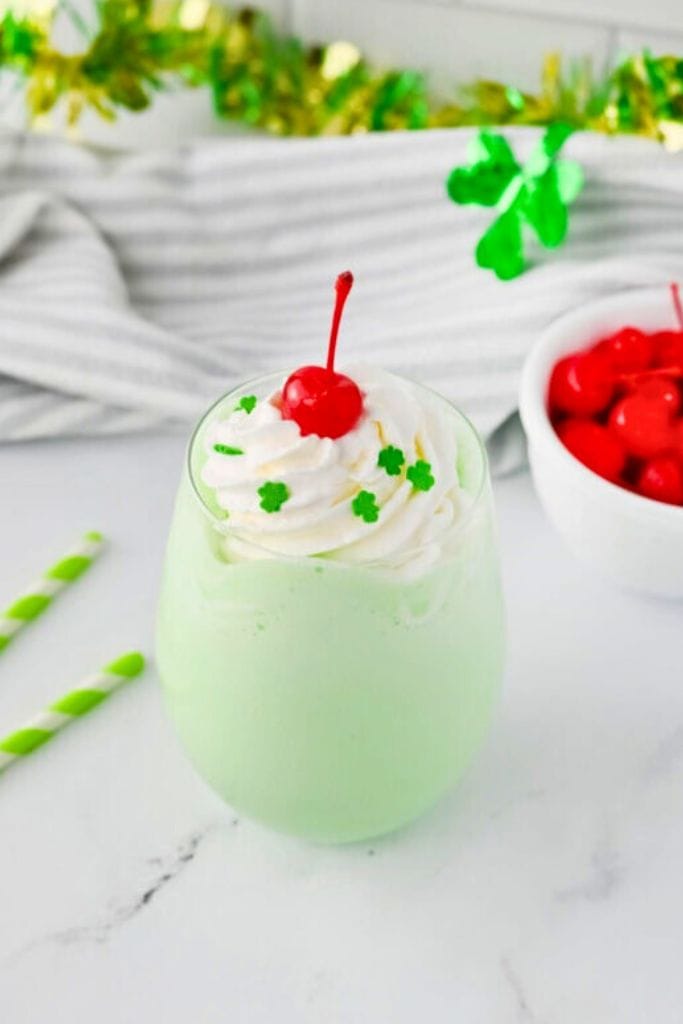 green shake with whipped cream and marachino cherry.