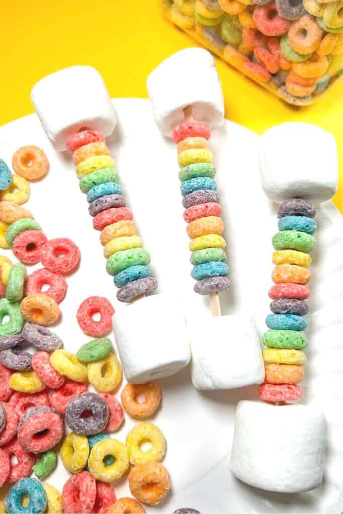 rainbow cereal threaded on sticks with marshmallows.