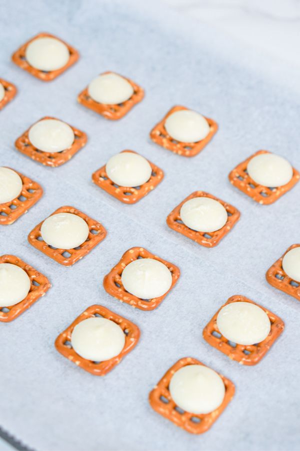 white candy melts on square pretzels.