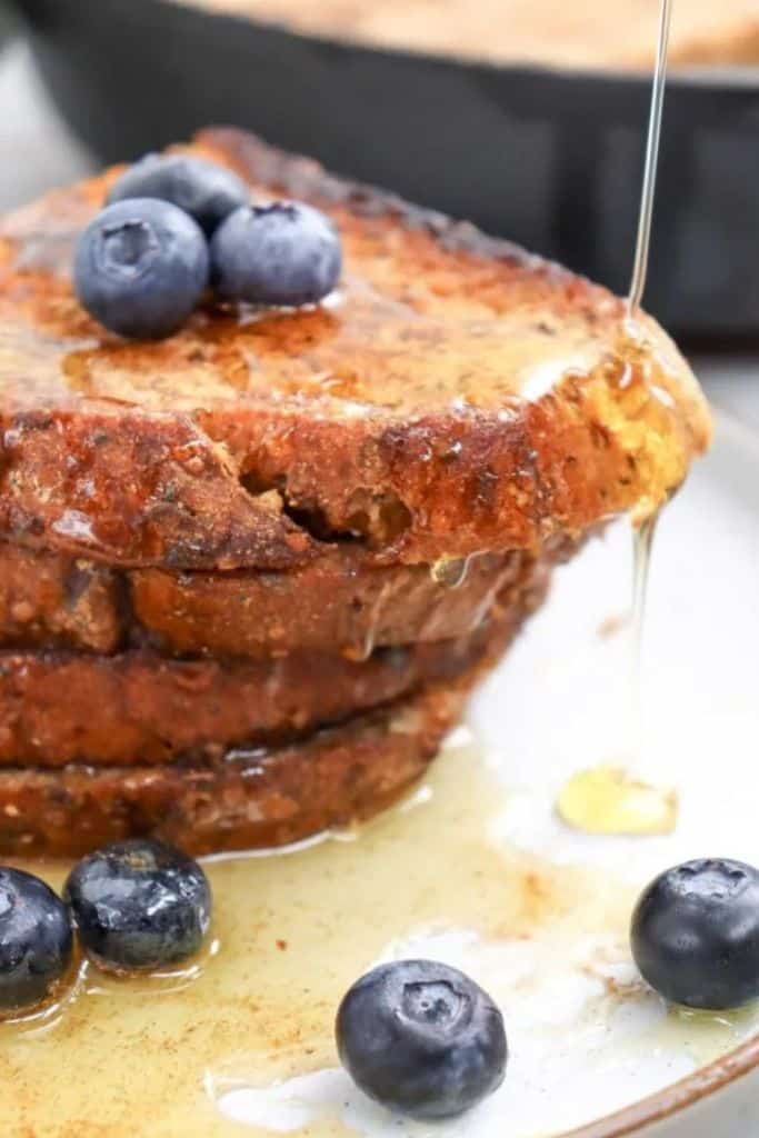 stack of cinnamon toast with syrup and berries.