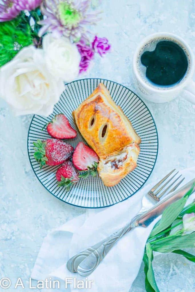 cheese and guava pastry on plate with fruit.