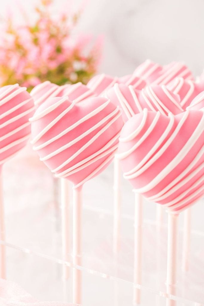 pink heart cake pops on stand.