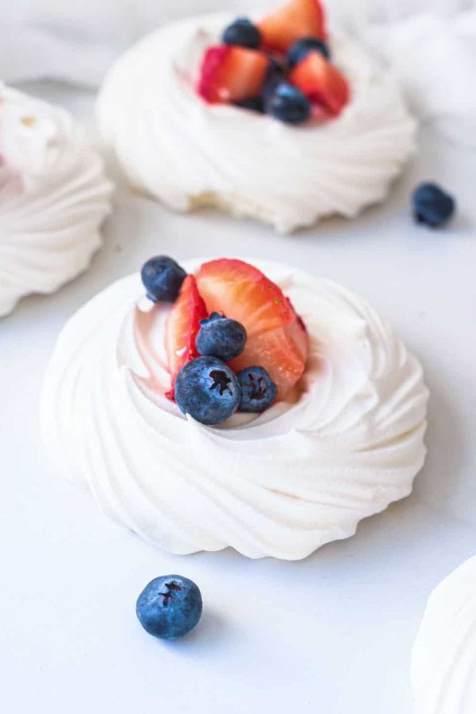 individual pavlova nests with berries.