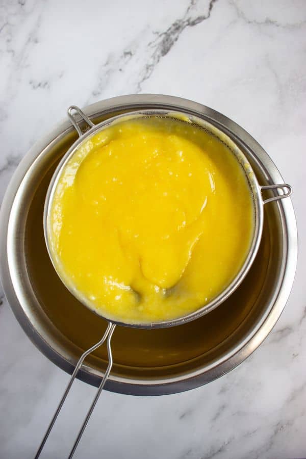 straining lemon curd into bowl.
