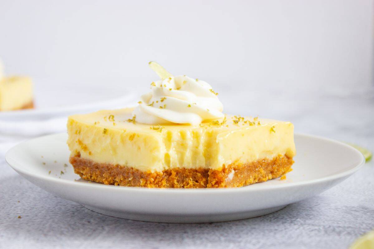 key lime bar on plate with cream on top.