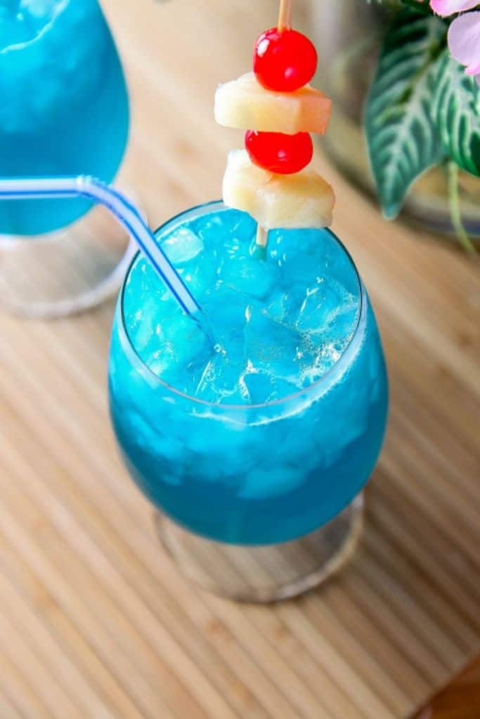 blue hawaiian cocktail in glass with straw.