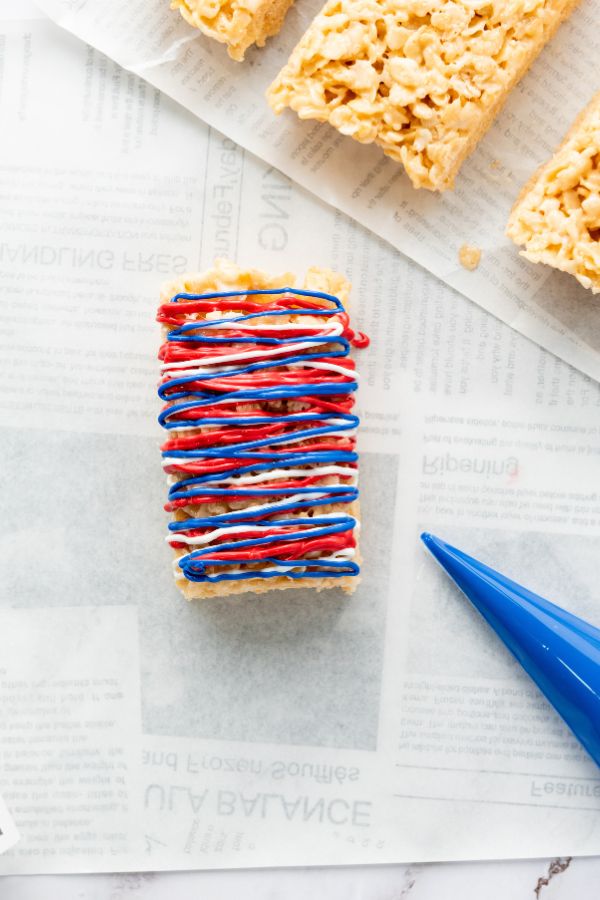 decorating patriotic snacks with blue melted chocolate.