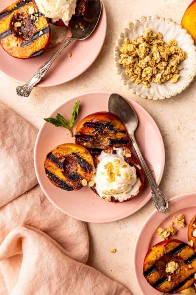 grilled peaches with ice cream on plate.