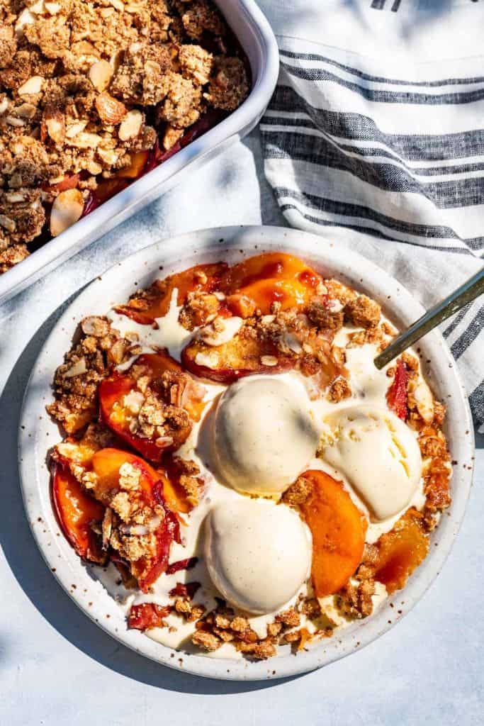 peach crisp with ice cream in bowl.